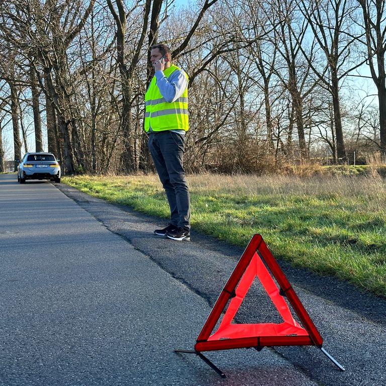 Absicherung einer Unfallstelle und Aufstellen eines Warndreiecks